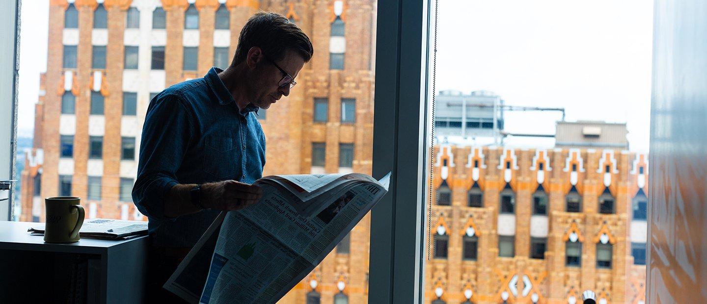一个人站在窗前看报纸